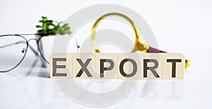 EXPORT concep on the wooden cubes and flower ,glasses ,coins and magnifier on white background