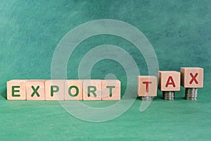 Export tax concept. Word in wooden blocks with increasing stack of coins.
