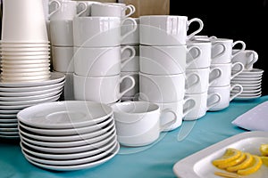 Exposed on stacks of white clean ceramic cups and saucers. Dishes in the restaurant for tea and coffee