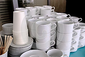 Exposed on stacks of white clean ceramic cups and saucers. Dishes in the restaurant for tea and coffee