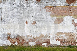 Exposed white stucco concrete red brick garden wall grass verge afternoon