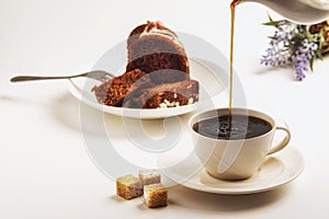 Exposition of chocolate cake with cup a coffee, coffee grinder on background. White background