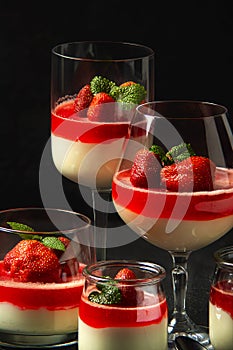 Exposition of fresh organic curd cream and jelly with strawberry on black background.