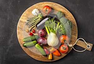 Exposition of fresh organic vegetables on wooden plate. tomato, pepper, broccoli, onion, garlic, cucumber,  eggplant, black Eyed P