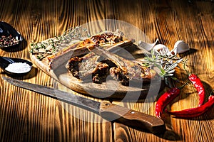 Exposition of mutton, fried lamb, barbecue lamb on wooden plate with chili pepper and garlic on wooden table.