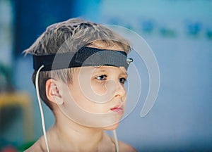 Express biofeedback microcurrent rezonans health of organs diagnostic. Sick child boy wear bioresonance head electrodes