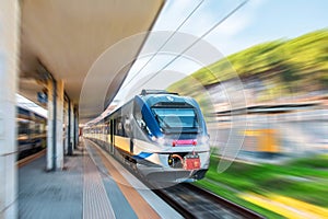 Express commuter suburban train passing through the passenger station