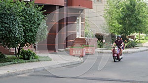 Express food delivery service. Delivery boy wearing red uniform on scooter with isothermal food case box