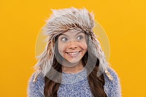 express positive emotion. winter fashion. happy kid with curly hair in earflap hat.