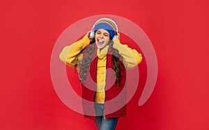 express positive emotion. winter fashion. teen girl in hat and earphones.