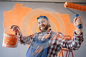 expression and people concept. Painter man holding painting roller and bucket with funny face