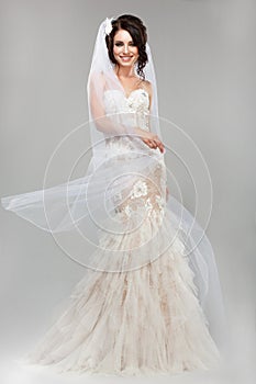 Expression. Positive Emotions. Gorgeous Smiling Bride in Windy Wedding Dress