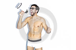 Expressive Caucasian Handsome Brunet Man Shouting With Loudspeaker While Posing in Underware Against White Background