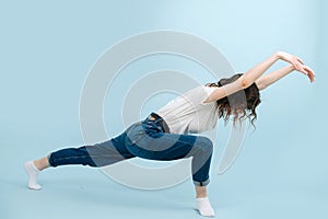 Expressive contemporary dancer lunging body forward, making wave like motions.