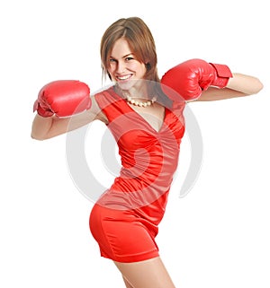 Expressive and emotional young woman in red dress and boxing gloves poses joyfully, isolate on white background, concept of beauty