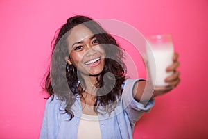 Expressive face of asian woman offering a glass of milk