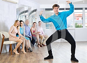 Expressive guy demonstrating krump dance moves in choreographic studio