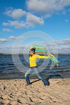 Expressive joyful woman happily goes to meet the wind, having