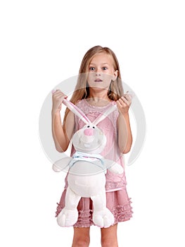 An expressive little girl holding a soft hare toy, isolated on a white background. Children, playing and rest concept.