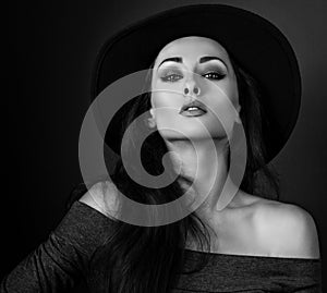 Expressive makeup woman in fashion elegant hat posing on dark sh