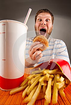 Expressive man eating fast food