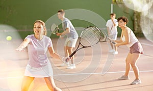 Expressive resolved fit girl playing frontenis ball friendly match on court