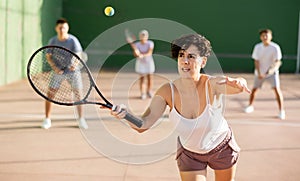 Expressive resolved fit girl playing frontenis ball friendly match on court