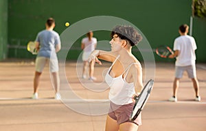 Expressive resolved fit girl playing frontenis ball friendly match on court