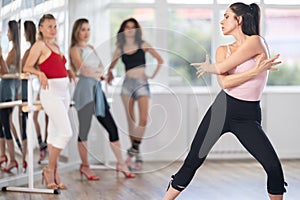 Expressive woman demonstrating movements of vogue dance in choreographic studio