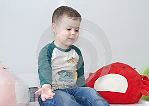 expressive young boy posing for portraits in his room surrounded by toys