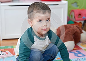 expressive young boy posing for portraits in his room surrounded by toys