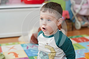 expressive young boy posing for portraits in his room surrounded by toys