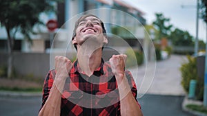 Expressive Young Man Showing Yes Winner Gesture. Happy amazed handsome male in plaid shirt standing rejoicing and