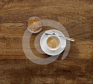 An expresso coffee, shot on a dark wooden background, with brown sugar in a bowl, with copy space