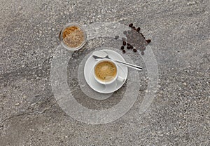 An expresso coffee, shot on a stone worktop, with coffee beans.