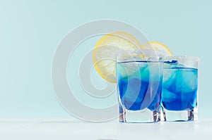 Exquisite blue cocktails for celebration in beach style with blue curacao, ice cube, sugar rim, lemon slice in mint color bar.