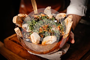 Exquisite decorated fish soup with sliced bread served in original bowl