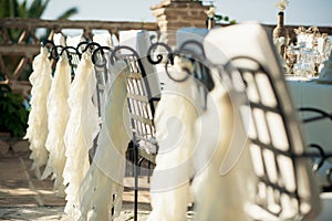 exquisite metal lace chairs and white chiffon make for an elegant atmosphere at this intimate outdoor wedding reception