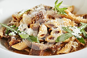 Exquisite Serving White Restaurant Plate of Homemade Italian Penne Pasta with Beef Cheeks Sauce