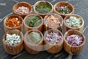 Exquisite variety of spices and seasonings presented in wooden bowls on dark surface