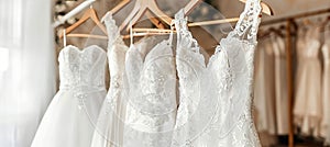 Exquisite white bridal gowns displayed on hangers in a sophisticated boutique bridal salon