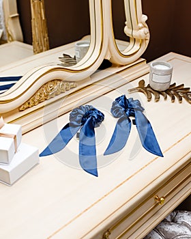Exquisite women's blue handmade silk scrunchy lie on table among luxury interior details.