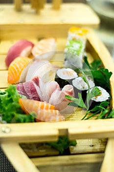 Exquisite wooden boat filled with different types of sushi and fish pieces