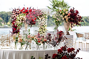 Exquisitely arranged and decorated wedding table outdoors on your wedding day. Beautiful flowers on the table on the wedding day.