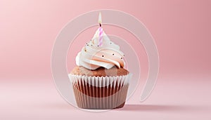 Exquisitely decorated birthday cupcake with flickering candle on light pink background