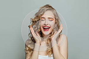 Exsited woman with healthy clear skin and blonde hair on white background