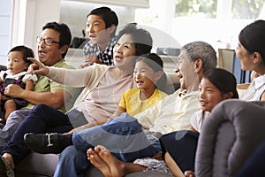 Extended Family Group At Home Watching TV Together