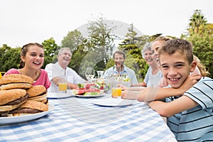 Extended family having dinner outdoors at picnic table