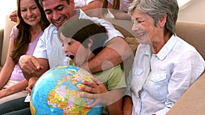 Extended family looking at globe together on couch