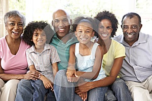 Extended Family Relaxing On Sofa At Home Together